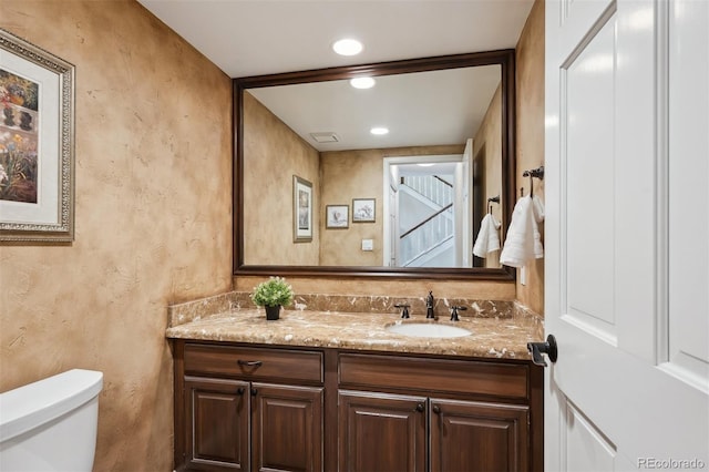 5320 S Geneva St, Englewood, CO 80111 - half bathroom featuring toilet, a textured wall, vanity, and recessed lighting