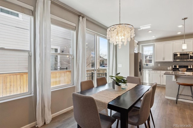 dining space with visible vents, dark wood finished floors, a notable chandelier, and baseboards