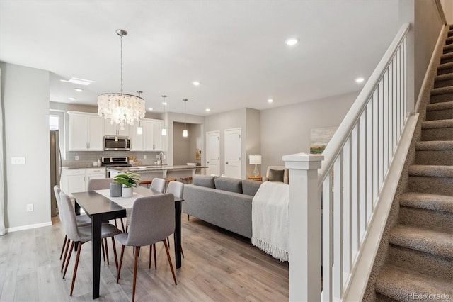 dining area featuring light wood-style flooring, stairway, baseboards, and recessed lighting