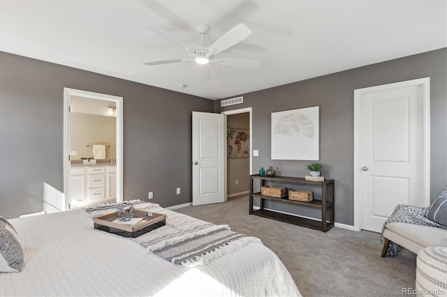 carpeted bedroom with visible vents, connected bathroom, baseboards, and ceiling fan