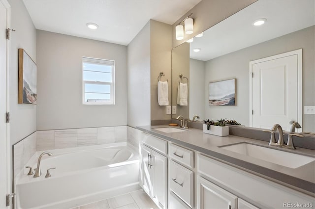 full bathroom with a bath, double vanity, a sink, and recessed lighting