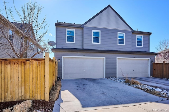 view of front of home with concrete driveway, an attached garage, and fence