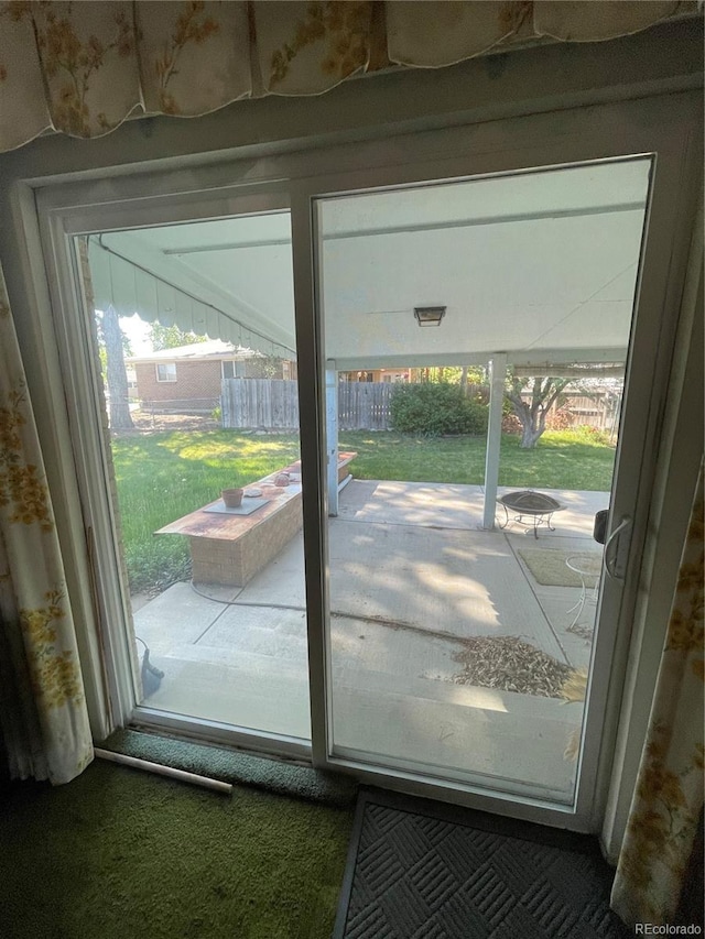 doorway to outside featuring healthy amount of natural light and carpet floors