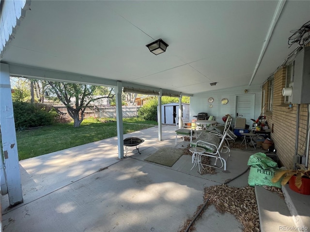 view of patio with an outdoor fire pit, a storage unit, and an outdoor structure