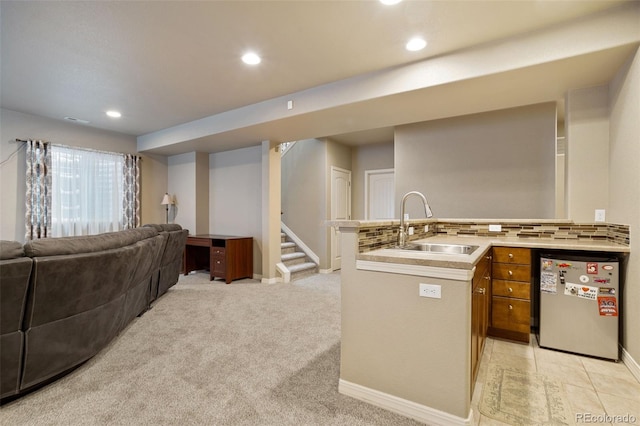 kitchen with backsplash, sink, light carpet, and stainless steel appliances