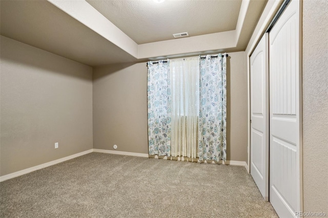 unfurnished bedroom with carpet flooring, a closet, and a textured ceiling