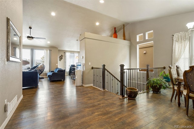 hallway with dark hardwood / wood-style floors and lofted ceiling