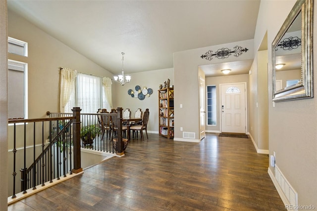 foyer featuring lofted ceiling, dark hardwood / wood-style floors, and an inviting chandelier