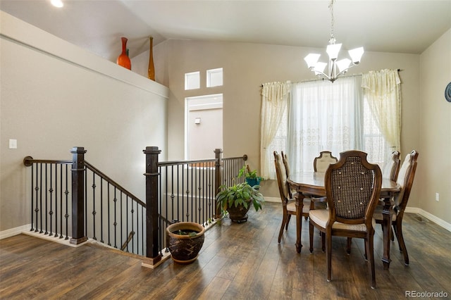 dining room featuring dark wood-type flooring, vaulted ceiling, and a notable chandelier