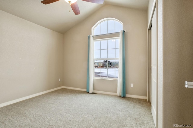 carpeted spare room with vaulted ceiling and ceiling fan