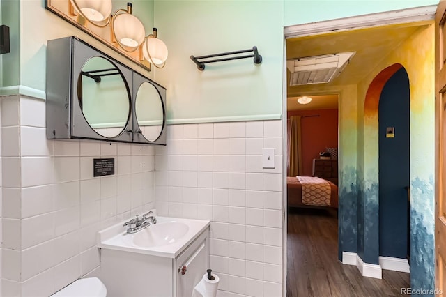 bathroom featuring tile walls, vanity, and wood finished floors