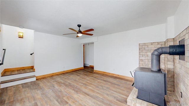 374 County Road 863, Tabernash, CO 80478 - unfurnished living room with a wood stove, ceiling fan, wood finished floors, and stairway
