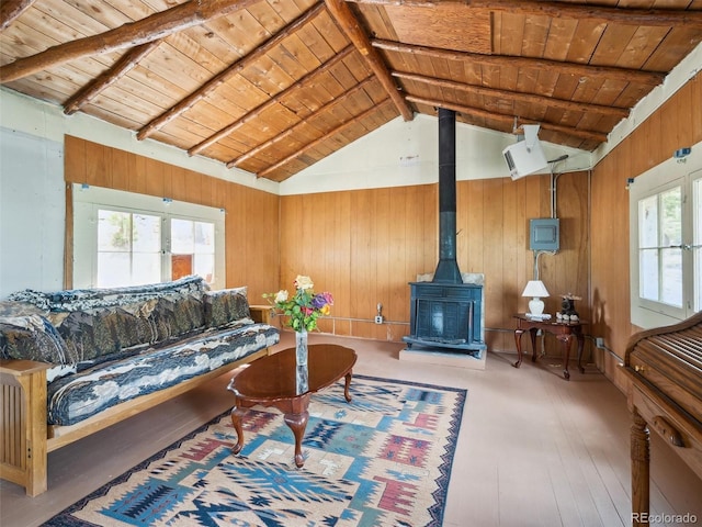 living area featuring wooden walls, wood ceiling, lofted ceiling with beams, and plenty of natural light
