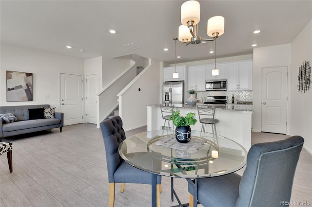 dining room with light hardwood / wood-style floors and a chandelier