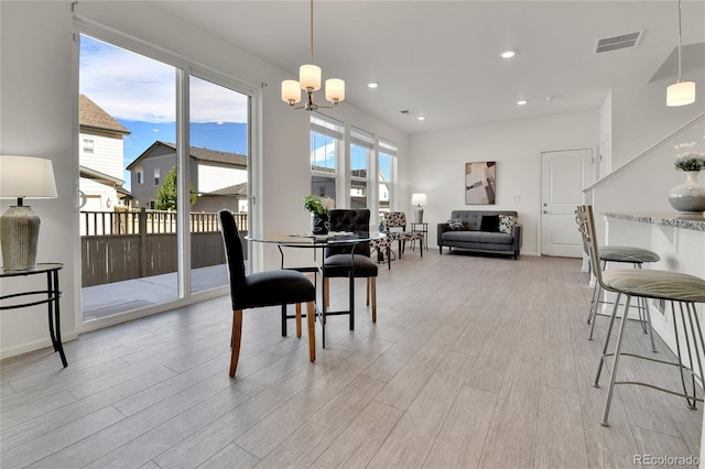 dining area featuring a notable chandelier and light hardwood / wood-style flooring