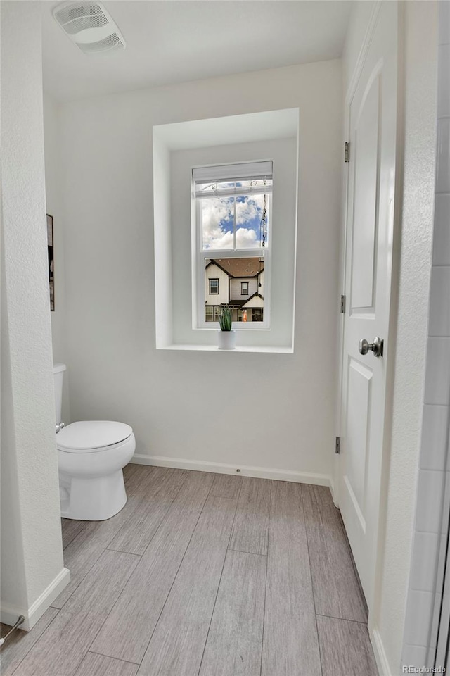 bathroom featuring hardwood / wood-style flooring and toilet