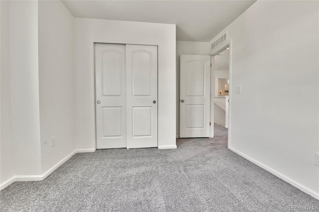 unfurnished bedroom featuring carpet and a closet