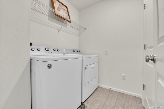 laundry room featuring light hardwood / wood-style floors and separate washer and dryer