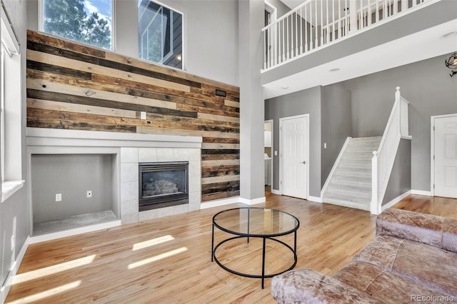 750 Deer Clover Cir, Castle Pines, CO 80108 - living area featuring stairway, wood finished floors, a high ceiling, and a fireplace