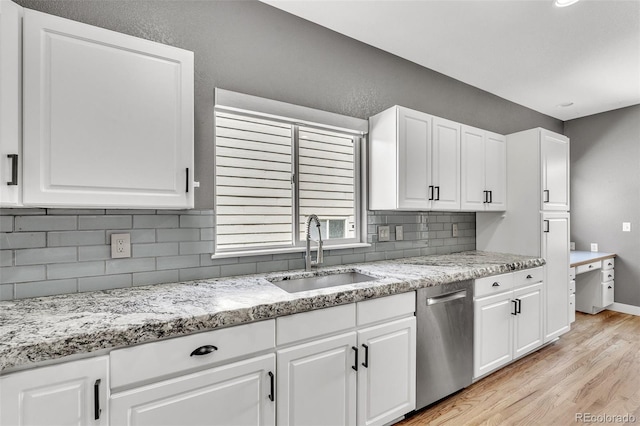 750 Deer Clover Cir, Castle Pines, CO 80108 - kitchen with stainless steel dishwasher, light wood-type flooring, tasteful backsplash, and white cabinetry