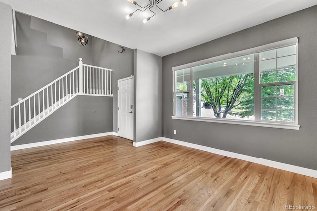 750 Deer Clover Cir, Castle Pines, CO 80108 - spare room with wood finished floors, a chandelier, and stairs