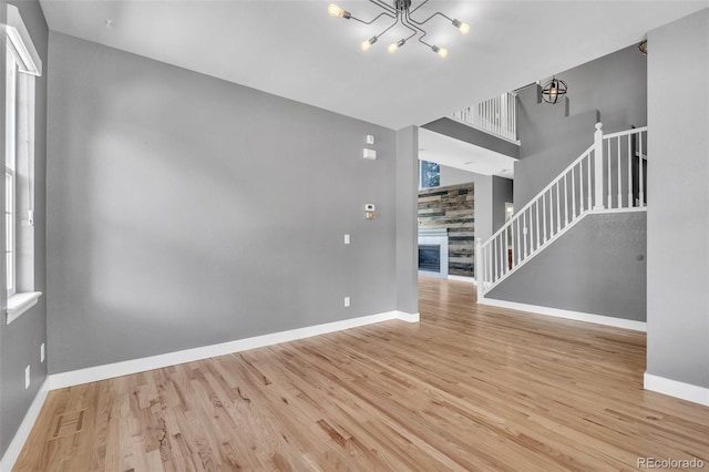 750 Deer Clover Cir, Castle Pines, CO 80108 - spare room with a chandelier, stairway, wood finished floors, and a glass covered fireplace