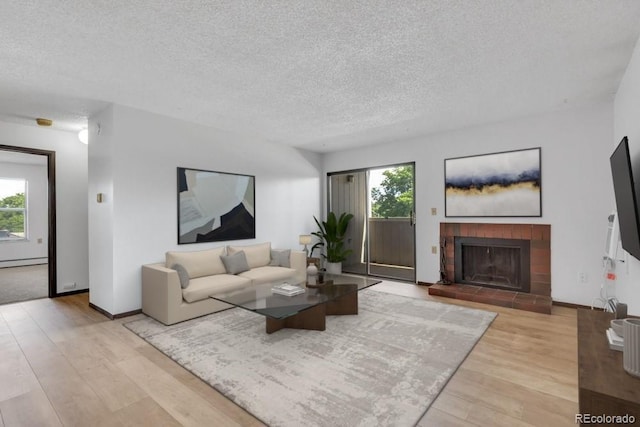 512 E Monroe Dr Unit D438, Fort Collins, CO 80525 - living area featuring healthy amount of natural light, wood finished floors, a textured ceiling, a fireplace, and a baseboard heating unit