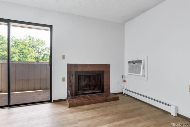 512 E Monroe Dr Unit D438, Fort Collins, CO 80525 - unfurnished living room with a baseboard heating unit, plenty of natural light, wood finished floors, a wall unit AC, and a textured ceiling