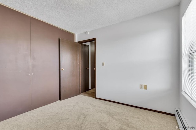 512 E Monroe Dr Unit D438, Fort Collins, CO 80525 - unfurnished bedroom featuring a baseboard heating unit, carpet flooring, a closet, and a textured ceiling