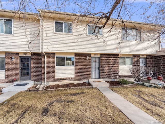 townhome / multi-family property featuring brick siding and a front lawn