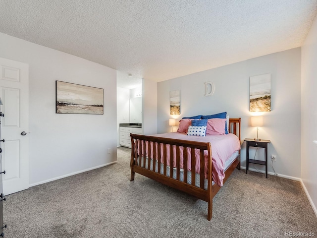 bedroom with carpet, connected bathroom, baseboards, and a textured ceiling