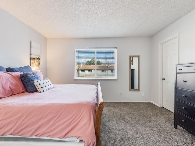 bedroom featuring carpet, baseboards, and a textured ceiling