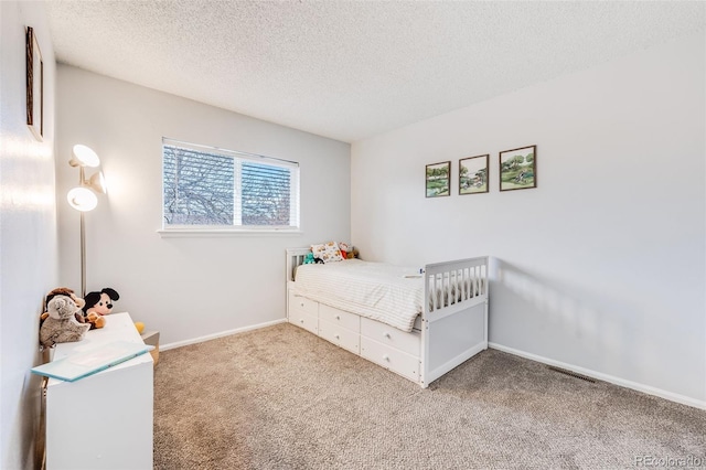 bedroom with carpet flooring, visible vents, baseboards, and a textured ceiling