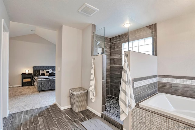 ensuite bathroom featuring a garden tub, visible vents, walk in shower, baseboards, and ensuite bath