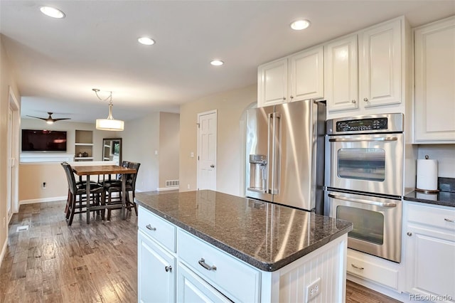 kitchen featuring a center island, light wood-style flooring, appliances with stainless steel finishes, and white cabinets
