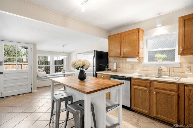 3842 Zenobia St, Denver, CO 80212 - kitchen featuring appliances with stainless steel finishes, a sink, light tile patterned floors, wooden counters, and a breakfast bar