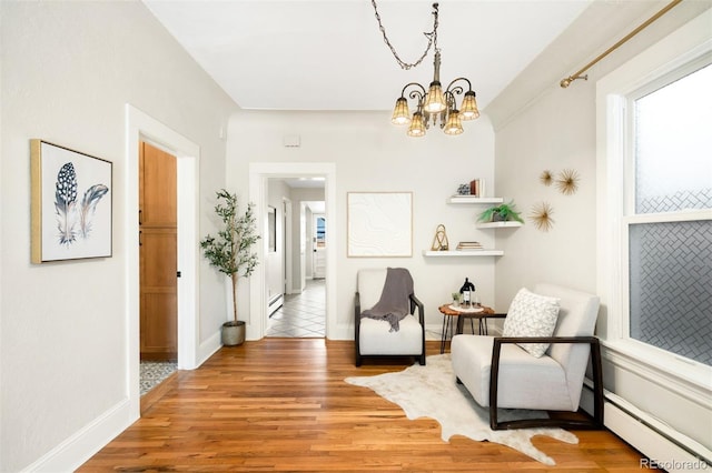 3842 Zenobia St, Denver, CO 80212 - living area featuring wood finished floors, baseboard heating, a chandelier, and healthy amount of natural light