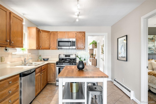 3842 Zenobia St, Denver, CO 80212 - kitchen featuring stainless steel appliances, baseboard heating, a sink, tasteful backsplash, and light tile patterned floors