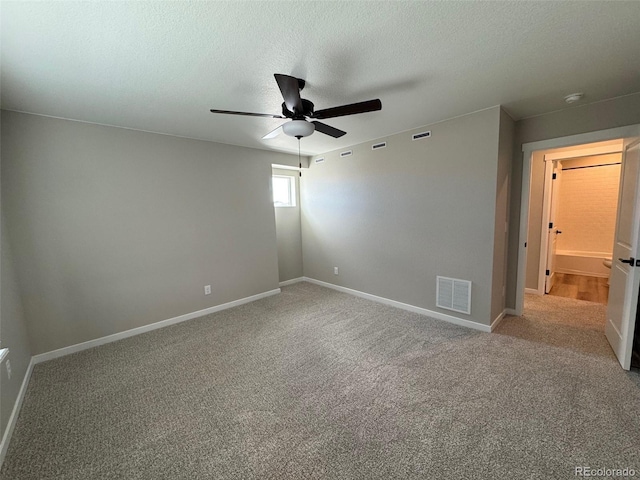 unfurnished bedroom with visible vents, a textured ceiling, carpet flooring, baseboards, and ceiling fan