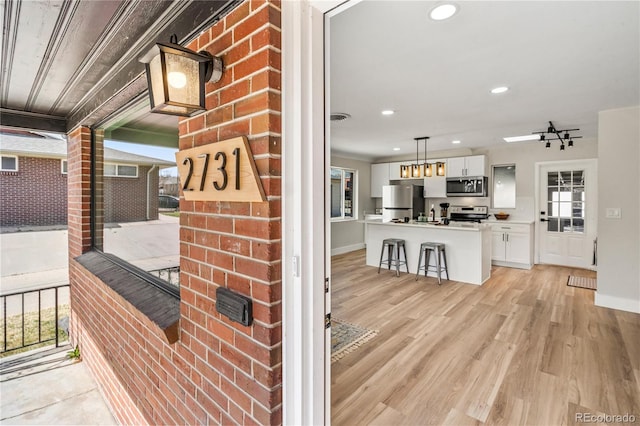 room details featuring wood finished floors, visible vents, baseboards, recessed lighting, and appliances with stainless steel finishes