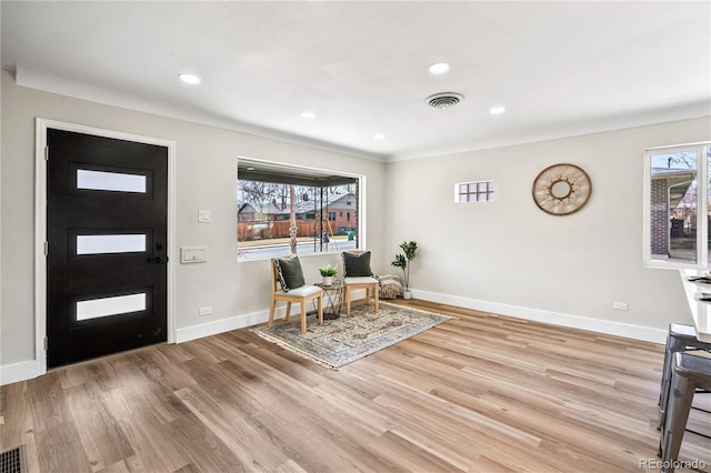 foyer entrance with visible vents, recessed lighting, baseboards, and wood finished floors