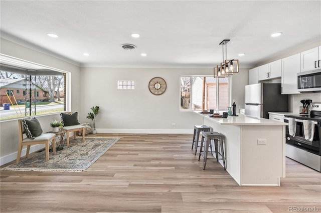 kitchen with light wood-style flooring, a healthy amount of sunlight, visible vents, and appliances with stainless steel finishes