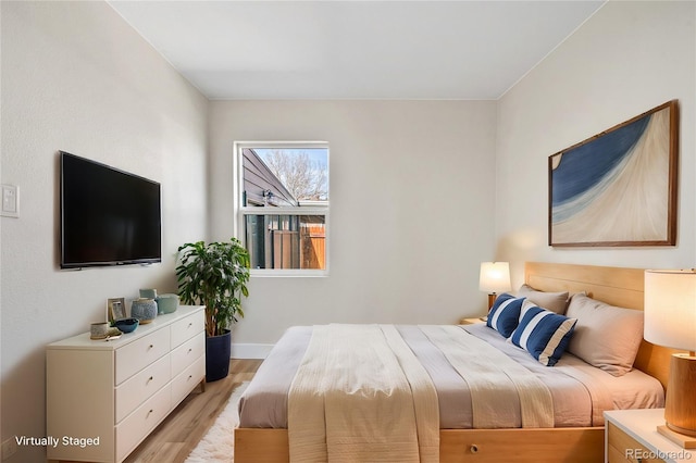 bedroom with light wood-type flooring and baseboards