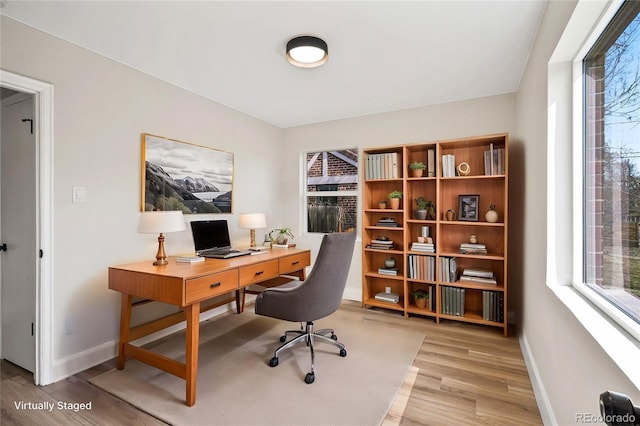 office featuring a wealth of natural light, baseboards, and light wood finished floors