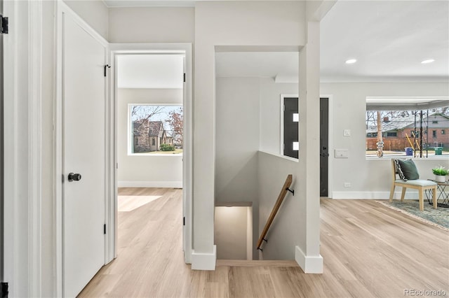 hall with recessed lighting, baseboards, an upstairs landing, and light wood finished floors