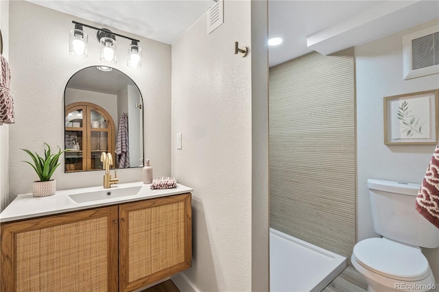 full bathroom with visible vents, vanity, toilet, and a shower