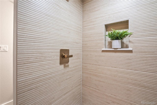 interior details featuring tiled shower