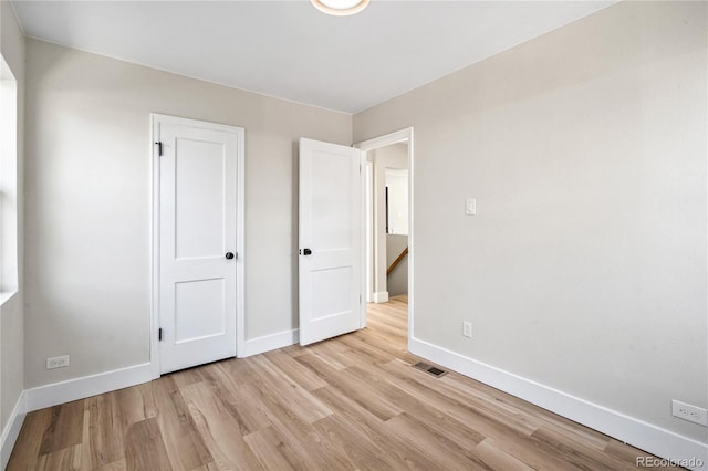 unfurnished bedroom with light wood-type flooring, baseboards, and visible vents