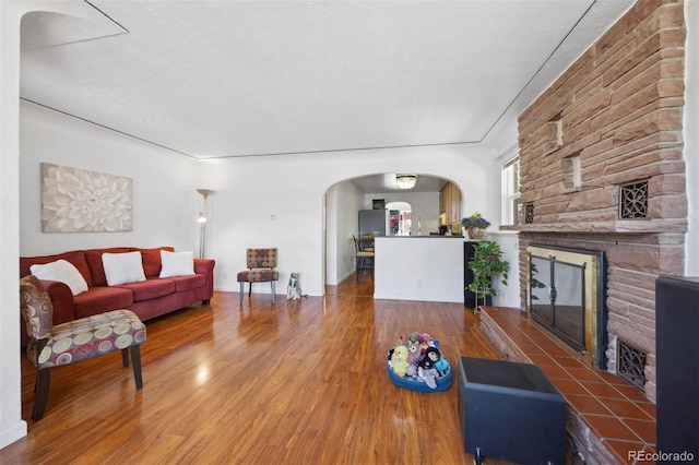 living room featuring hardwood / wood-style flooring, a fireplace, and a textured ceiling