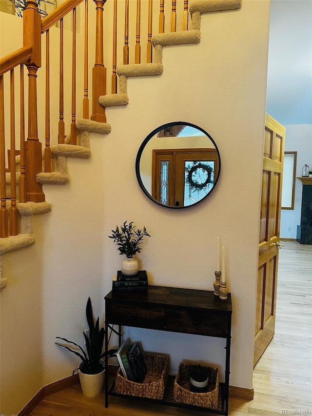 stairway with baseboards and wood finished floors